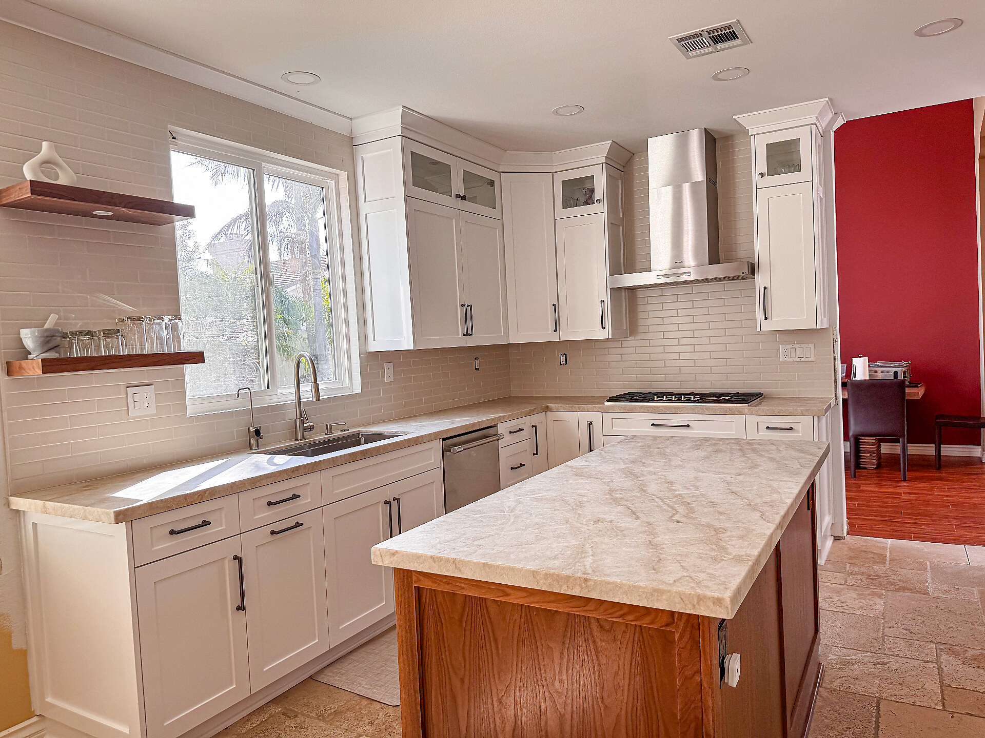 Taj Mahal quartzite kitchen with stainless hood and travertine floors